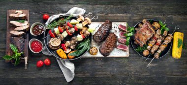 Ahşap arka planda sebzeli ızgara et. Barbekü menüsü. Üst görünüm, kopyala boşluk, afiş, panorama