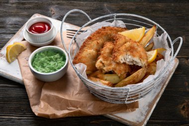 Geleneksel İngiliz balık ve patates kızartması. Bezelye püresi ve farklı soslarla servis edilir.. 