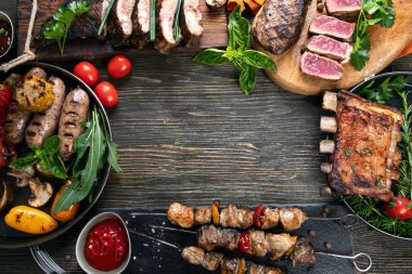 Ahşap arka planda sebzeli ızgara et. Barbekü menüsü. Üst görünüm, alanı kopyala.