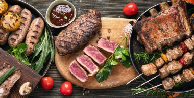 Ahşap arka planda sebzeli ızgara et. Barbekü menüsü. Üst görünüm, alanı kopyala.