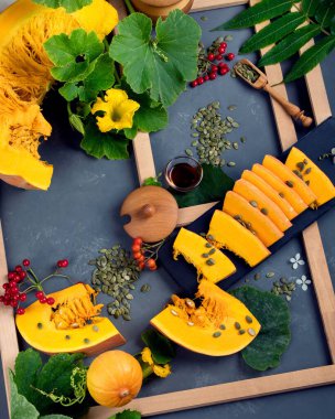 Çiğ balkabağı, böğürtlen ve yapraklardan yapılan şenlikli sonbahar dekoru. koyu arkaplanda