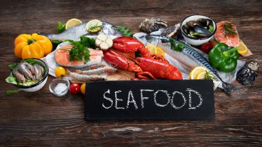 Kırsal ahşap arka planda taze balık ve deniz ürünleri, baharatlar ve sebzeler. Dengeli beslenme ve pişirme konsepti