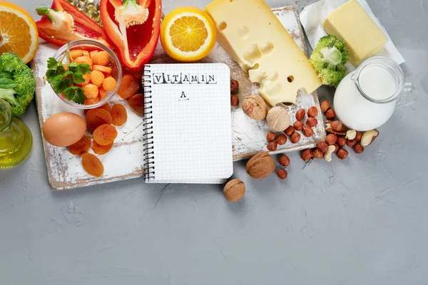 Foods high in vitamin A. Natural products rich in vitamin A. Important for normal vision, the immune system, and reproduction. Copy space, Top view, notebook.