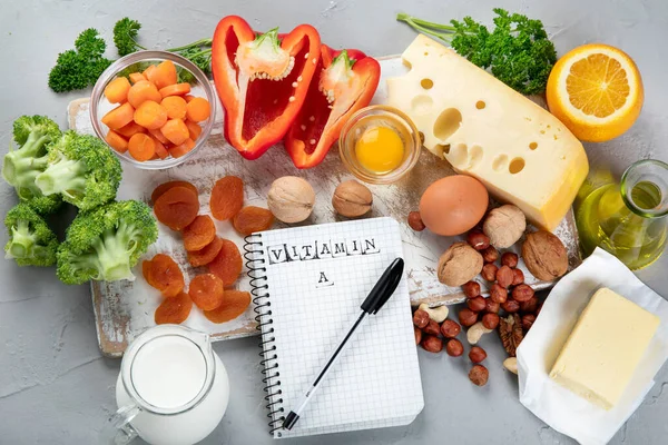 Foods high in vitamin A. Natural products rich in vitamin A. Important for normal vision, the immune system, and reproduction. Top view, notebook.