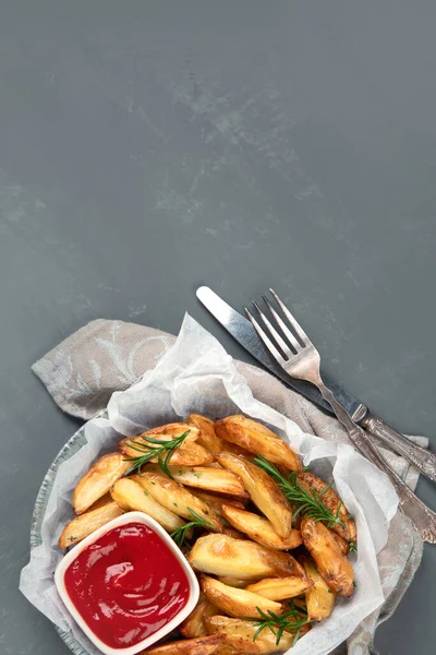 Baked country style potato wedges with herbs and sauce. Top view, copy space