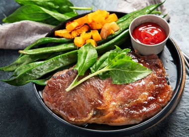 Sebzeli biftek. Koyu arkaplanda sağlıklı plaka