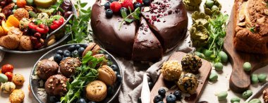 Çeşitli vejetaryen tatlılar, çikolatalı pasta, muzlu pasta, fındık ve tatlı. Üst Manzara. Panorama.