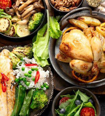 Siyah arka planda çeşitli et yemekleri, balık, salata, garnitür ve atıştırmalıklar. Üst Manzara. Boşluğu kopyala.