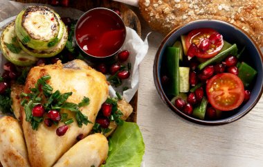 Hafif arka planda sebzeli, soslu ve salatalı tam kızarmış tavuk. Üst Manzara. Kopyalama alanı olan Panorama.