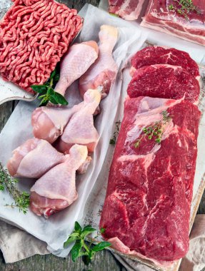 Kırsal ahşap arka planda çiğ et çeşitleri. Üst manzara, düz uzanma 