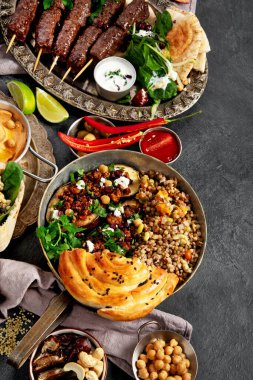 Orta Doğu ya da Arap mutfağı. Arka planda çeşitli yemekler var. Üst görünüm.