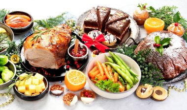 Noel temalı yemek masasında kızarmış et, aperatifler ve tatlılar. Tatil kavramı. 