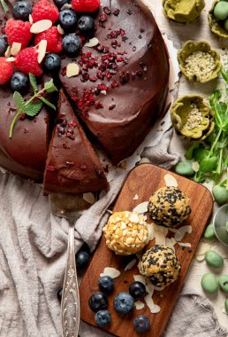 Böğürtlenli vejetaryen çikolatalı pasta ve hafif arka planda atıştırmalıklar. Üst görünüm