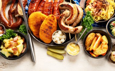 Çeşitli Avustralya yemekleri... Şnitzel, sosis, patates, Knodel, salata ve soslar hafif arkaplanda. Üst Manzara. Boşluğu kopyala.