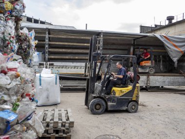 Kharkov, Ukrayna - 17 Mayıs 2018: Yükleme çuval daha fazla işlem için gönderilmek üzere kamyon içine ezilmiş plastik şişe ile