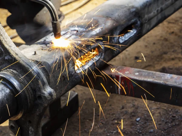 Metal work. Man cuts a hole in a steel piece using gas welding