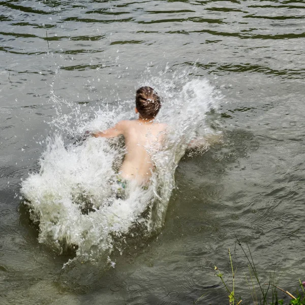 Kaukasischer Junge Springt Einem Teich Ins Wasser Und Wirft Spritzwasser — Stockfoto