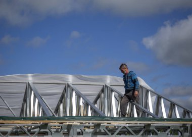 Beyaz erkekler çatı kaplama işi gerçekleştirir. Nem bariyeri montajı