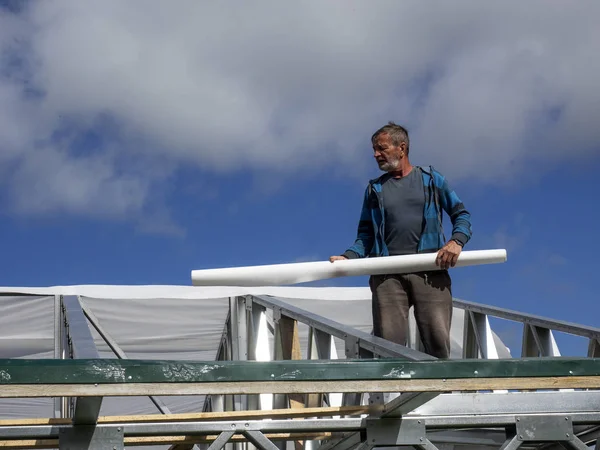 Beyaz erkekler çatı kaplama işi gerçekleştirir. Nem bariyeri montajı