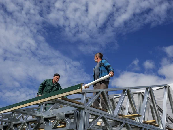 Beyaz erkekler çatı kaplama işi gerçekleştirir. Nem bariyeri montajı