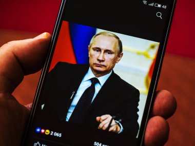 KIEV, UKRAINE - Oct 7, 2018: Portrait of President  Vladimir Putin  on Facebook account seen displayed on a smart phone clipart