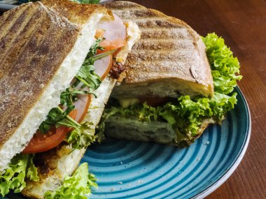 Tavuk ve jambonlu sandviç roka ve domates ile