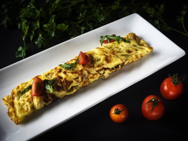 omlet koyu ahşap zemin üzerine bir tabak içinde 