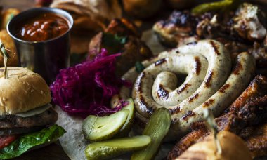 Meze tabağı soğuk et tabağı ile prosciutto, dilim jambon, kurutulmuş et, salam ve roka ahşap arka plan üzerinde kesme tahtası üzerinde yakın. Etli meze