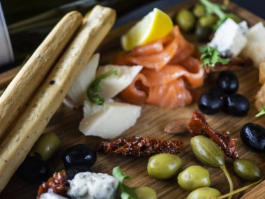 Peynir tabağı ile somon, limon, olivas ve ekmek stcks