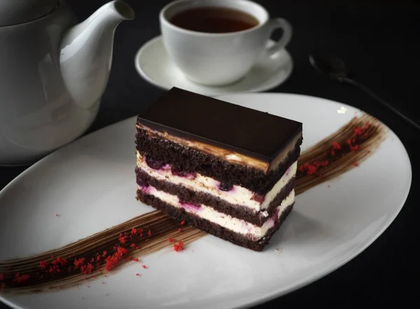 Cheesecake Σοκολάτας Στο Φόντο Της Ένα Τσαγιέρα Και Ένα Φλιτζάνι — Φωτογραφία Αρχείου