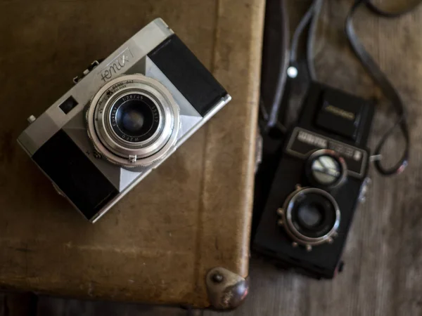 Παλιές φωτογραφικές μηχανές φιλμ στο φόντο του vintage βαλίτσα — Φωτογραφία Αρχείου