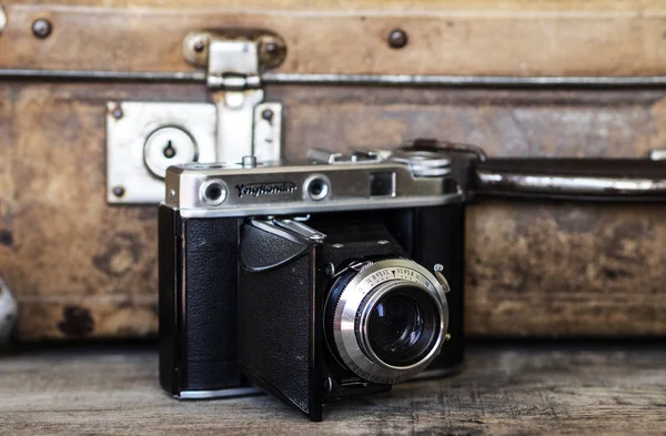 व्हिंटेज सूटकेस पार्श्वभूमीवर जुना रोल चित्रपट कॅमेरा — स्टॉक फोटो, इमेज