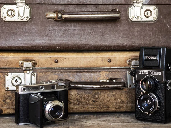 Câmeras de filme rolo velho no fundo da mala vintage — Fotografia de Stock