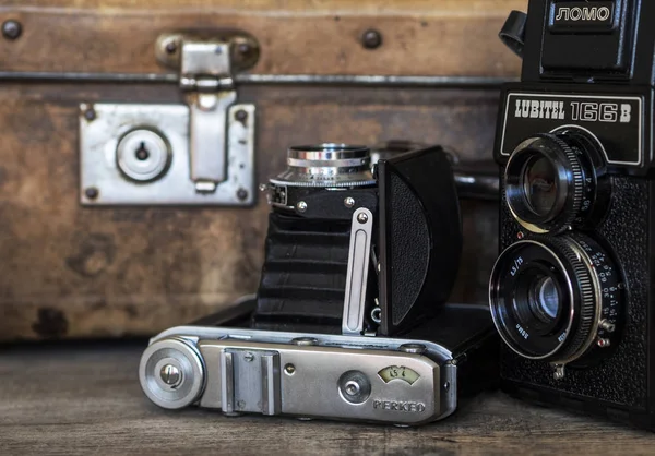 Régi tekercs film fényképezőgép, a háttérben a vintage táska — Stock Fotó