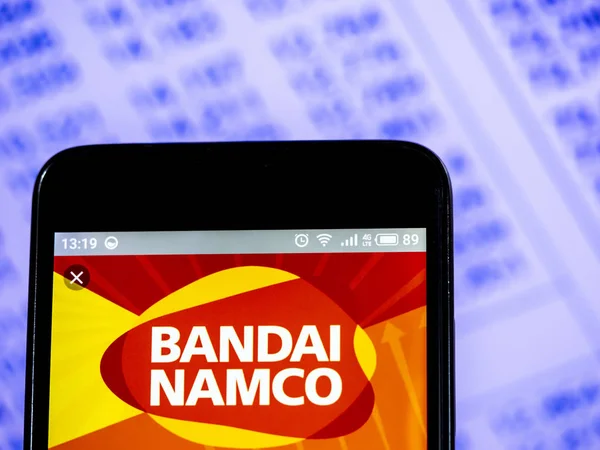 Логотип компанії Namco Bandai Holdings Инк бачив відображене на смарт — стокове фото