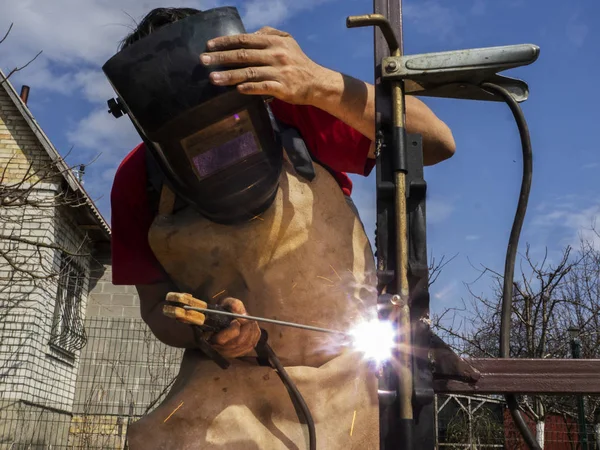 Man is welded to a steel gate metal latch. — Stock Photo, Image