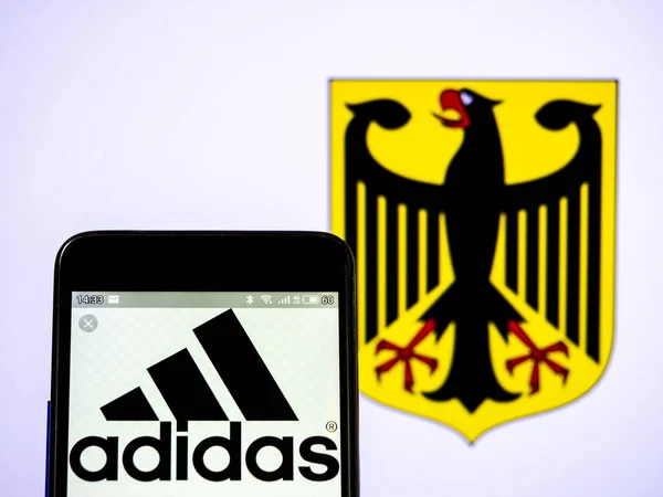 У цій ілюстрації фото Adidas AG логотип видно відображається на — стокове фото