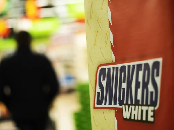 Logo Snickers White at the entrance to the supermarket — Stock Photo, Image
