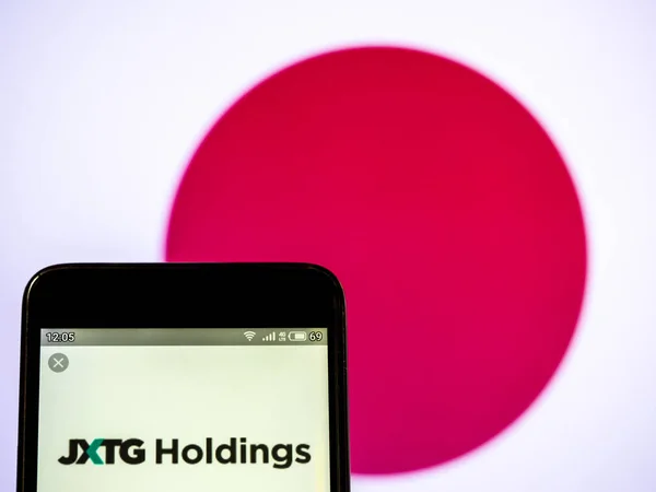 In this photo illustration a JXTG Holdings logo seen displayed o — Stock Photo, Image