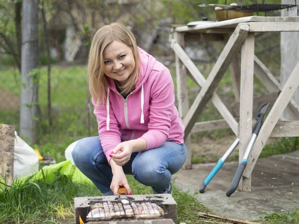 Kaukasische blonde Frau bereitet Grill vor — Stockfoto