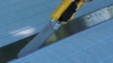 Bir parça polipropilen ısıtıcıyı inşaat bıçağıyla kesin