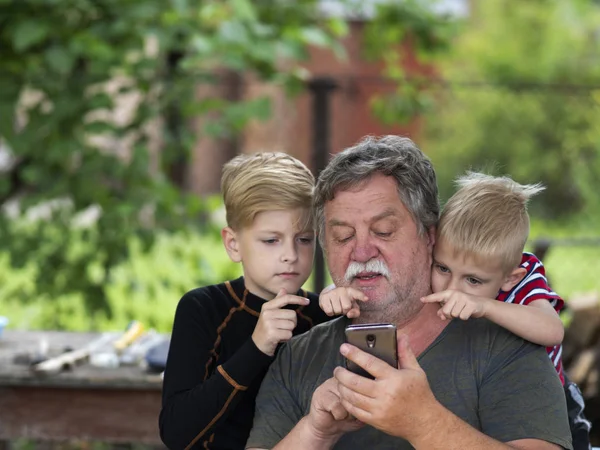 Kaukasische grijs harige man van middelbare leeftijd met kleinkinderen zijn co — Stockfoto