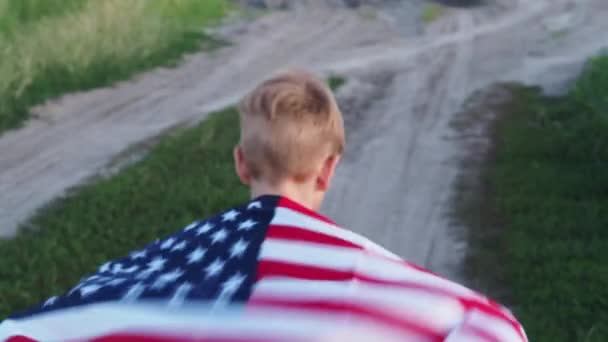 Kaukasischer Junge Mit Amerikanischer Flagge Auf Den Schultern Läuft Vor — Stockvideo