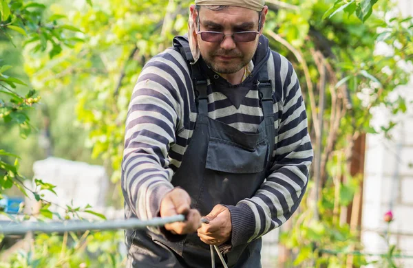 Volwassen Blanke Man Trekt Kabel Door Metalen Beschermhoes — Stockfoto