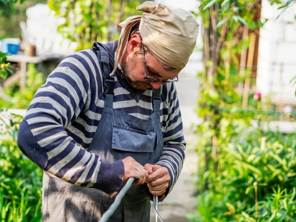 Volwassen Blanke Man Trekt Kabel Door Metalen Beschermhoes — Stockfoto