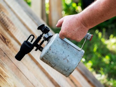 Kaynak makinesiyle tahta yakan bir adamın eli.