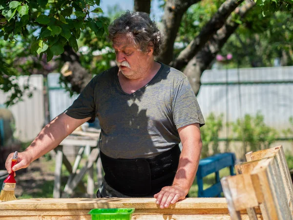 Senior Caucasian Man Covers Boards Solution Decay Brush Garden — Stock Photo, Image