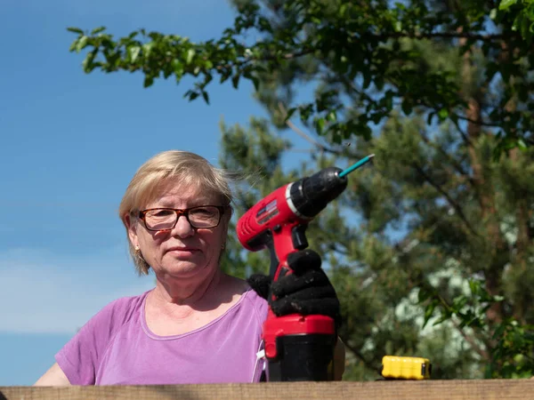 Senior Caucasian Woman Fastens Board Roof Farm Building Garden Screwdriver — Stock Photo, Image