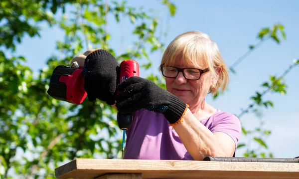 Senior Vit Kvinna Fäster Bräda Taket Till Gård Byggnad Trädgården — Stockfoto