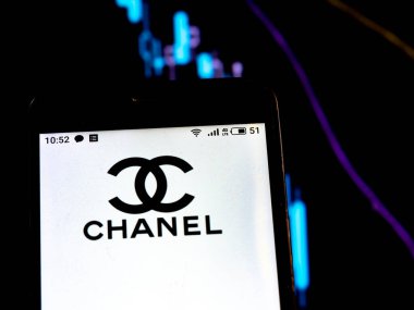 Bu resimde Chanel logosu, bir grafiğin arka planında düşen eğrilerle bir akıllı telefonda görüntülenir. Uluslararası basında çıkan haberlere göre Coronavirus salgını sırasında COVID-2019 Chanel durduruldu.